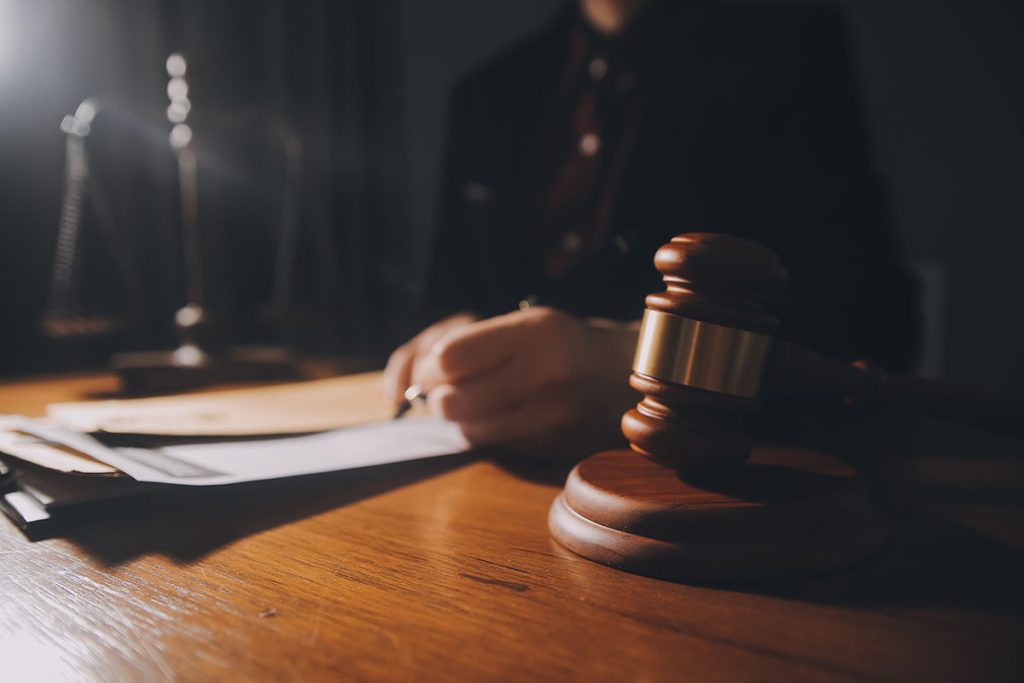 Law,Books,And,Scales,Of,Justice,On,Desk,In,Library